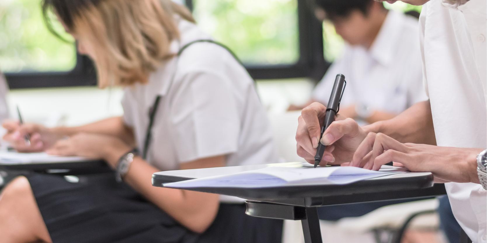 Education concept with college student's taking exam, having knowledge learning assessment test in school classroom